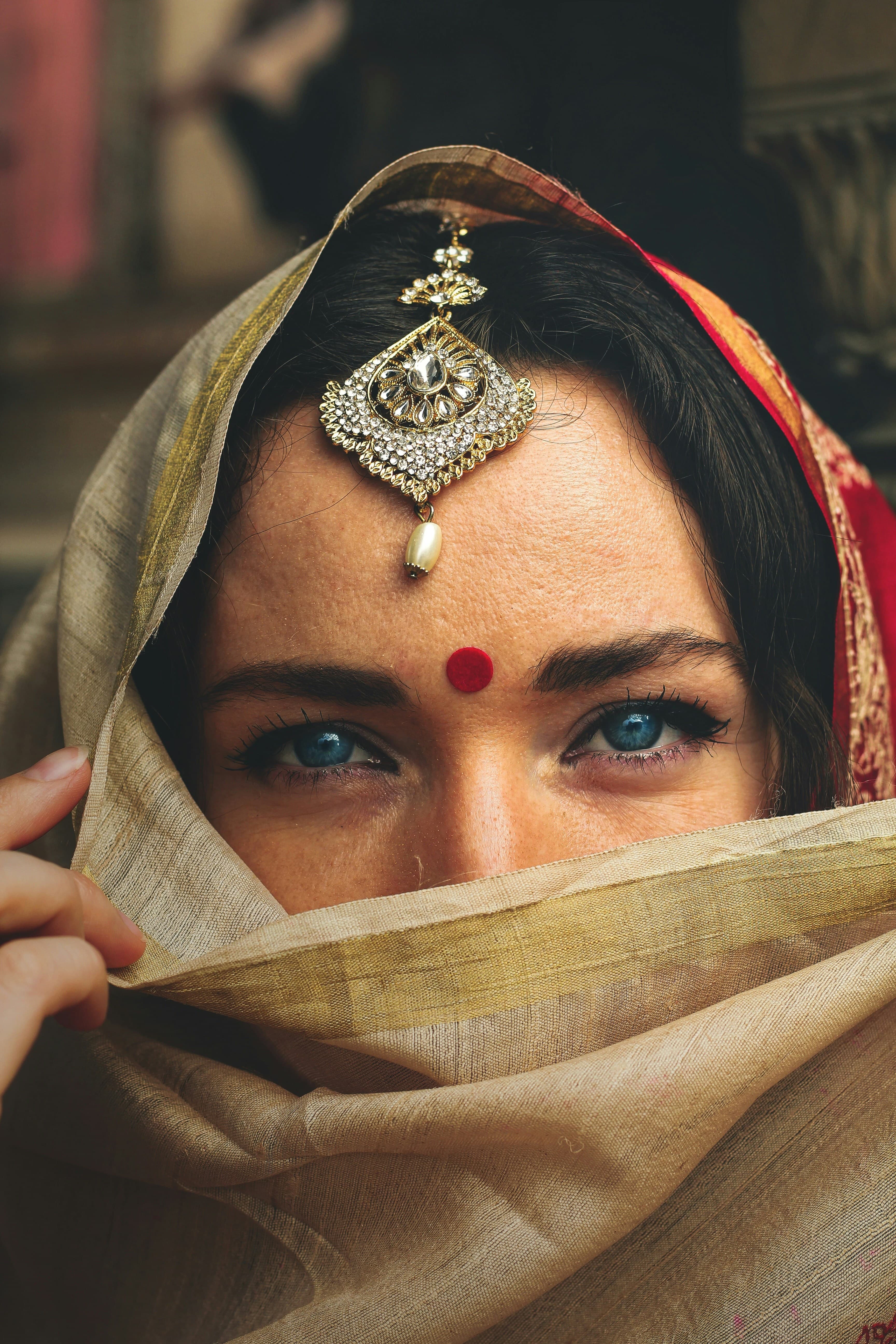 Close view of a maang tikka worn over a silk dupatta