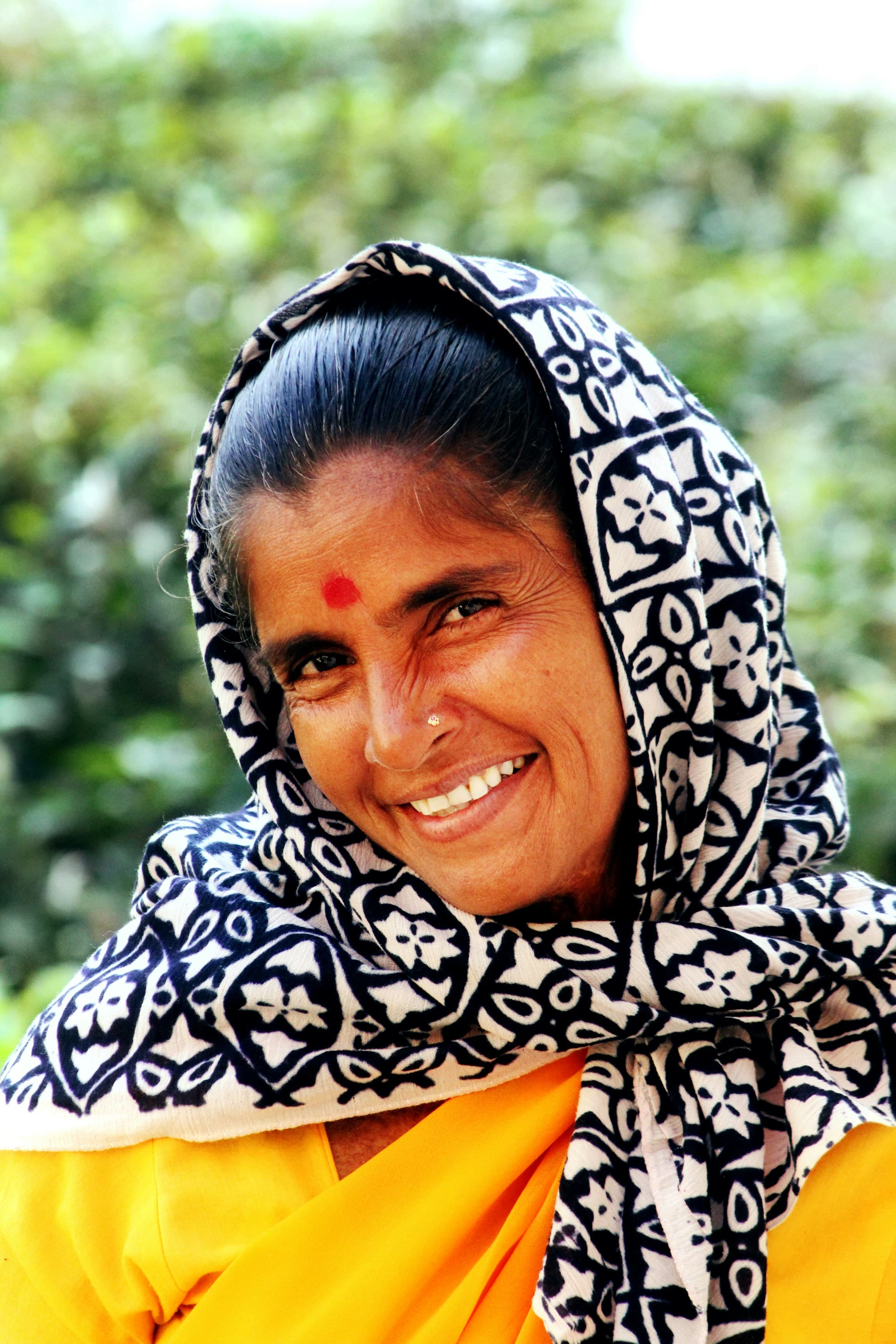 Smiling woman in a yellow saree with a printed dupatta